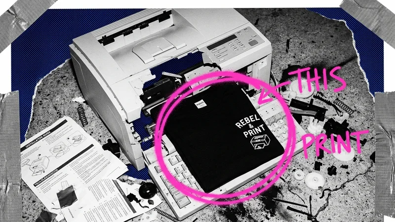 A messy DIY merch setup with a shirt on a printer and notes pointing at a complicated tool stack.